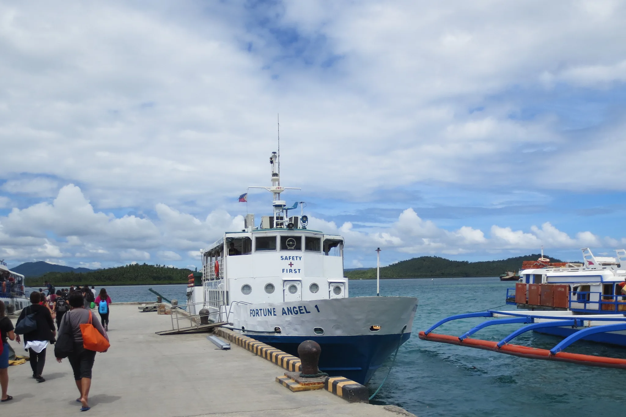 Photo: Wolfgang Hägele (CC BY-SA 4.0) Passengers walking the pier at Dapa Port, Siargao, alongside a docked passenger ferry