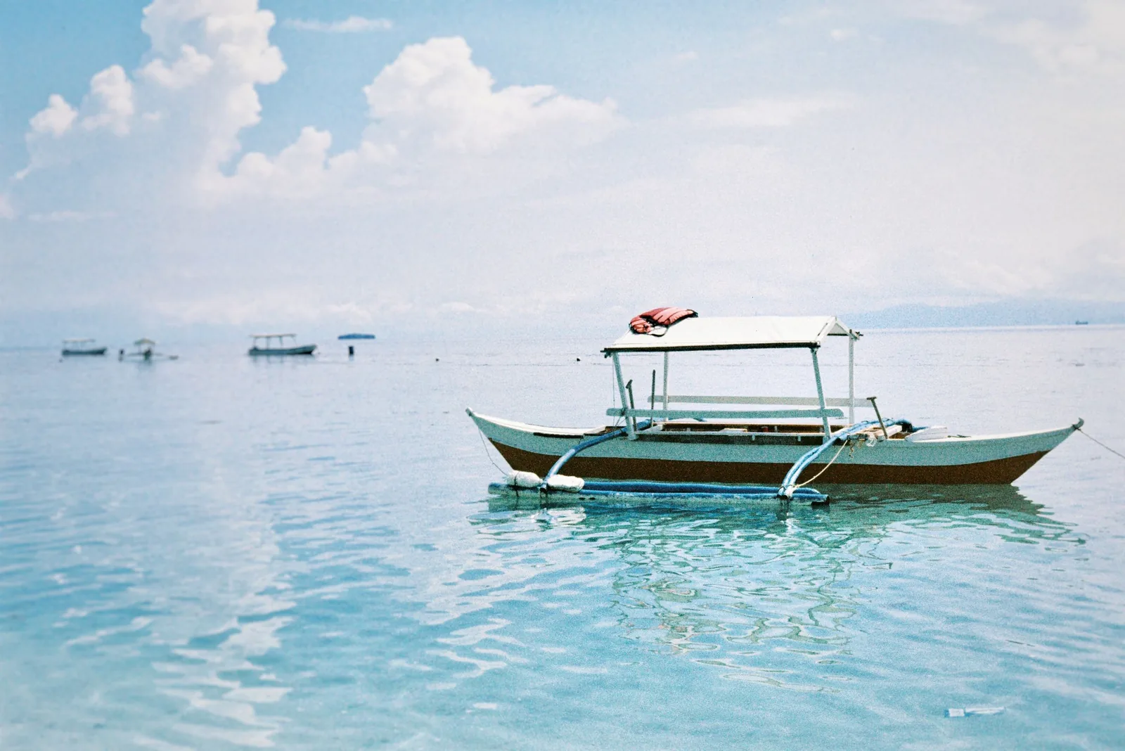 Photo: Rob Volz (Pexels License) A traditional Filipino bangka outrigger boat on clear blue water